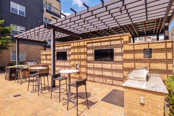 A patio with a table and chairs under a pergola. at Bridge at Henley, Austin, TX